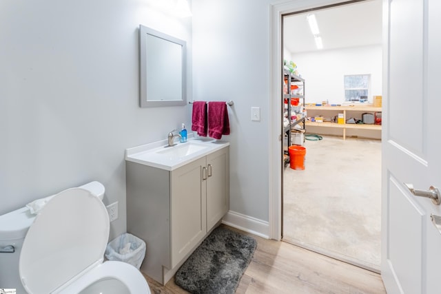 bathroom with vanity, toilet, and hardwood / wood-style flooring