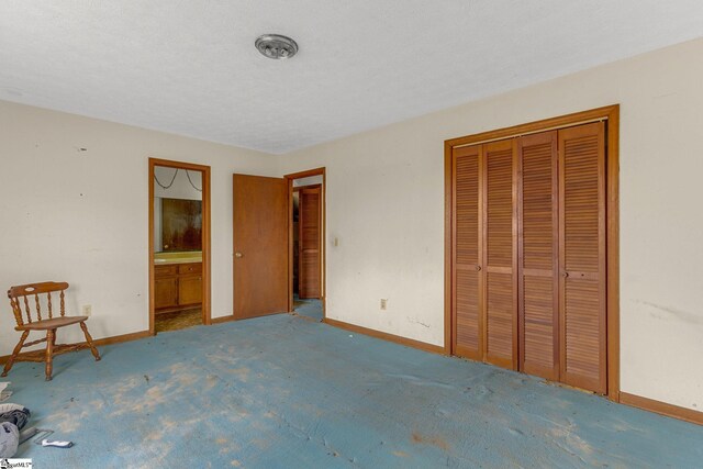 unfurnished bedroom featuring a closet and ensuite bathroom