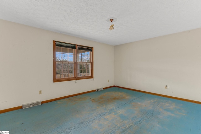 spare room with a textured ceiling and carpet floors