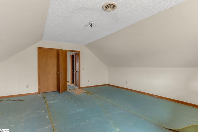 bonus room featuring vaulted ceiling and a textured ceiling