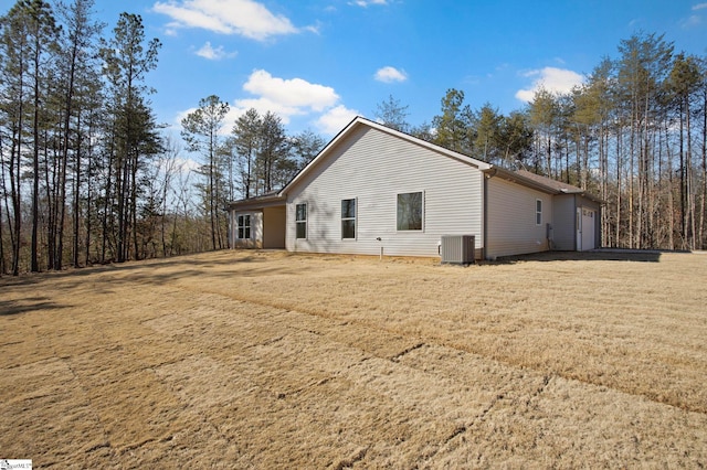 view of side of property featuring a lawn and central air condition unit