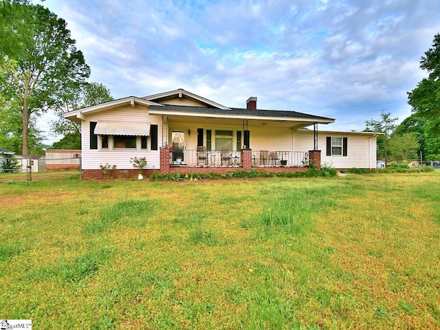 view of front of home with a porch and a front lawn