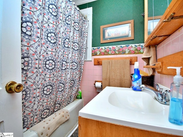 bathroom with tile walls, vanity, crown molding, and shower / bath combination with curtain