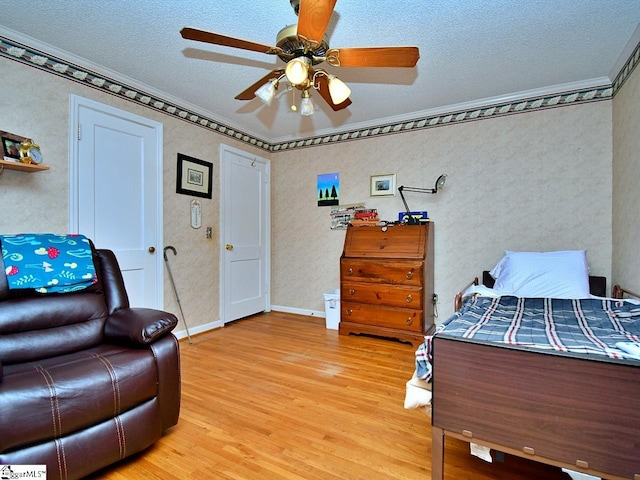 bedroom with light hardwood / wood-style flooring, ceiling fan, and a textured ceiling