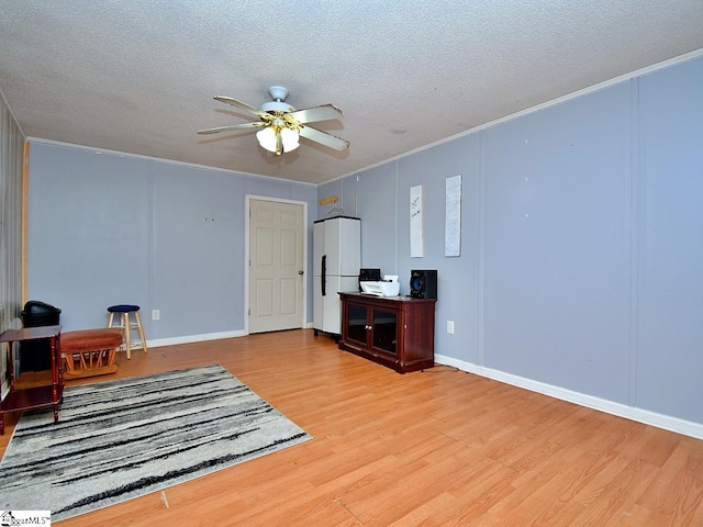 interior space featuring crown molding, light hardwood / wood-style flooring, ceiling fan, and a textured ceiling