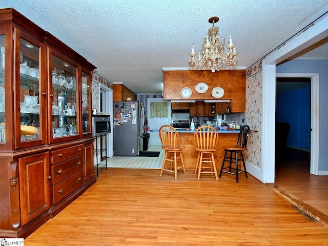 tiled dining area featuring a chandelier and a textured ceiling