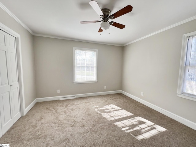 unfurnished room with a healthy amount of sunlight, carpet floors, ceiling fan, and ornamental molding