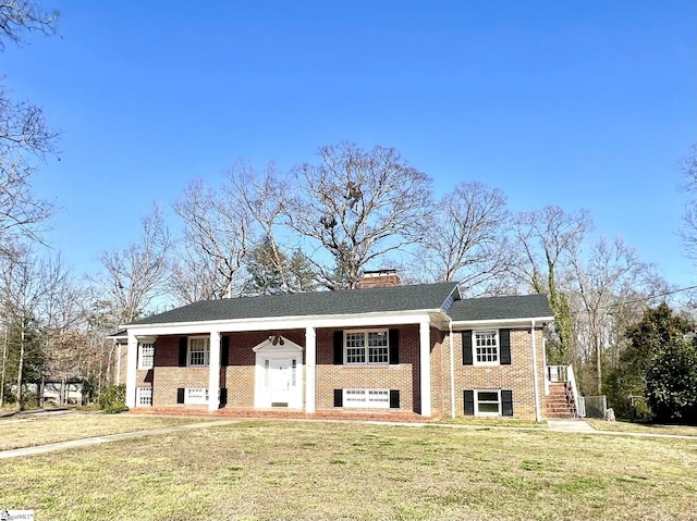 raised ranch featuring covered porch and a front yard