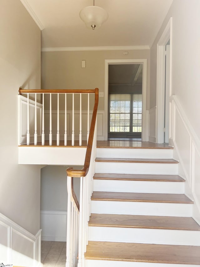 stairs with crown molding and tile floors