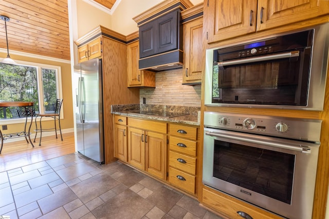 kitchen featuring ornamental molding, lofted ceiling, decorative backsplash, appliances with stainless steel finishes, and light stone countertops