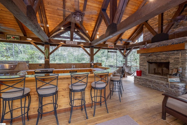 exterior space with a gazebo, area for grilling, a fireplace, and an outdoor wet bar