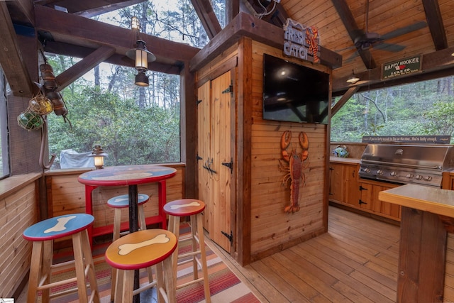 exterior space featuring lofted ceiling with beams, ceiling fan, and plenty of natural light