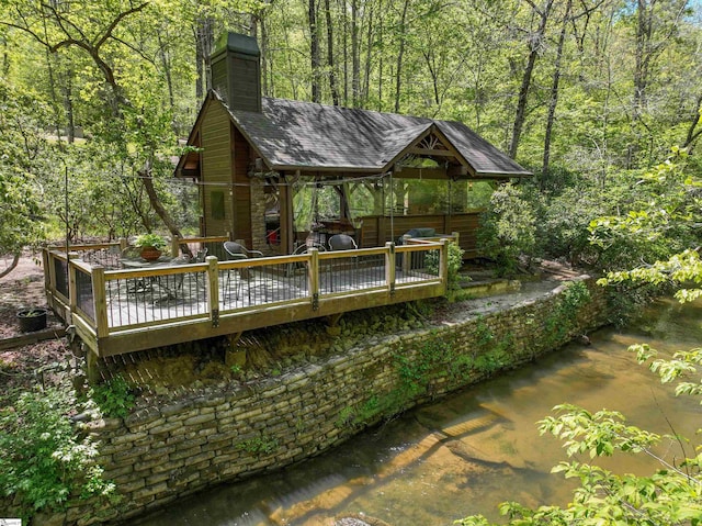 back of property featuring a deck with water view