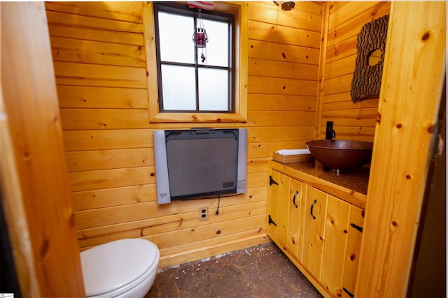 bathroom featuring heating unit, wood walls, vanity, and toilet