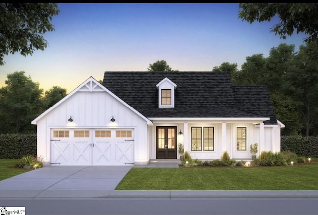 view of front of home with french doors, a garage, and a yard