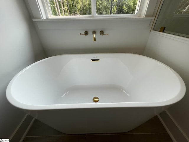 bathroom with tile patterned floors and a bath