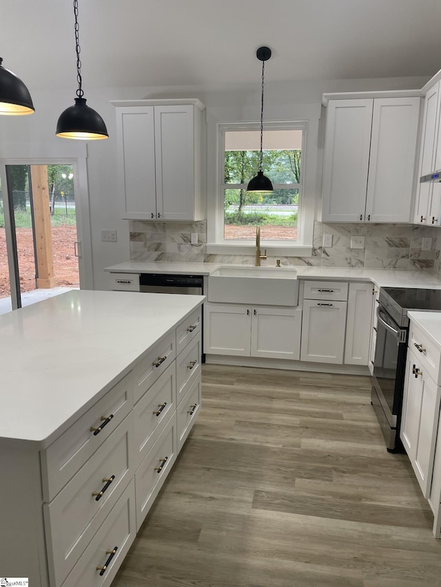 kitchen featuring range with electric stovetop, white cabinetry, sink, and decorative backsplash