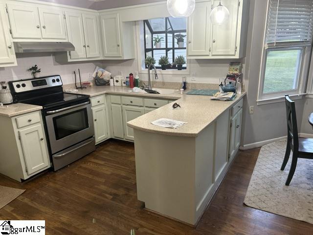 kitchen with sink, white cabinetry, dark wood-type flooring, stainless steel electric stove, and kitchen peninsula