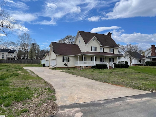 view of front of house featuring a front yard, a garage, and covered porch