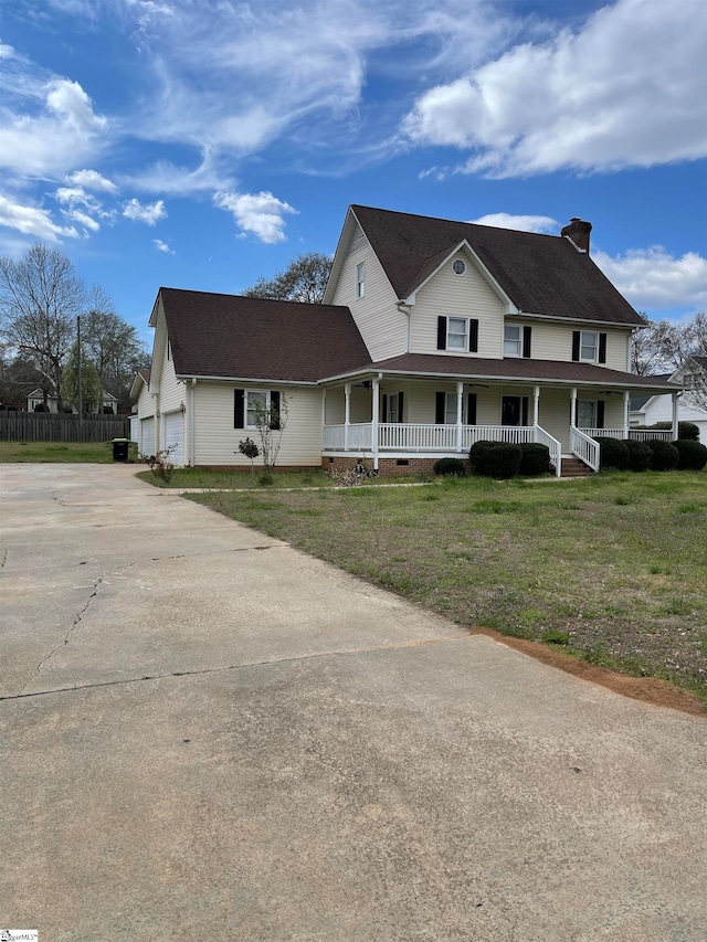 view of front of property with a front yard, a garage, and covered porch