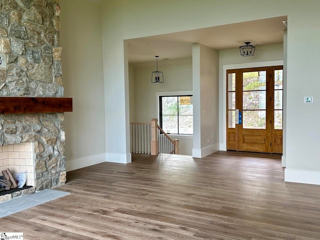 foyer with hardwood / wood-style flooring, plenty of natural light, and a fireplace