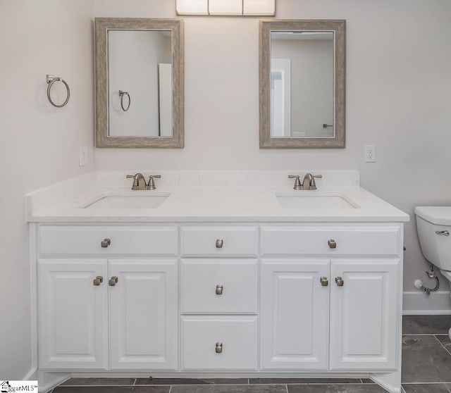 bathroom featuring tile flooring, double vanity, and toilet