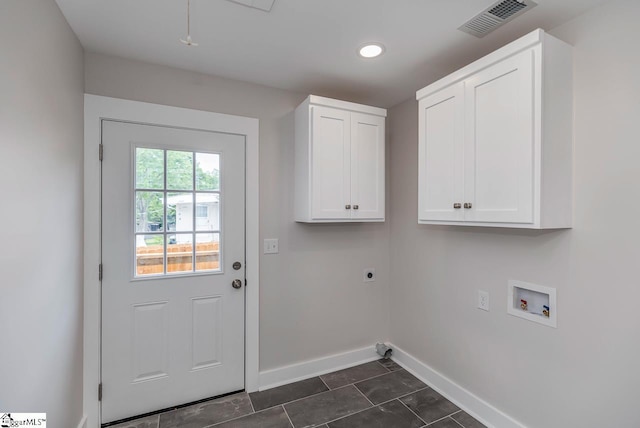 laundry area with cabinets, dark tile flooring, hookup for an electric dryer, and washer hookup