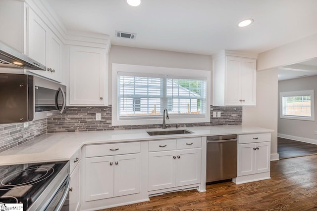 kitchen with white cabinetry, dark hardwood / wood-style floors, backsplash, stainless steel appliances, and sink