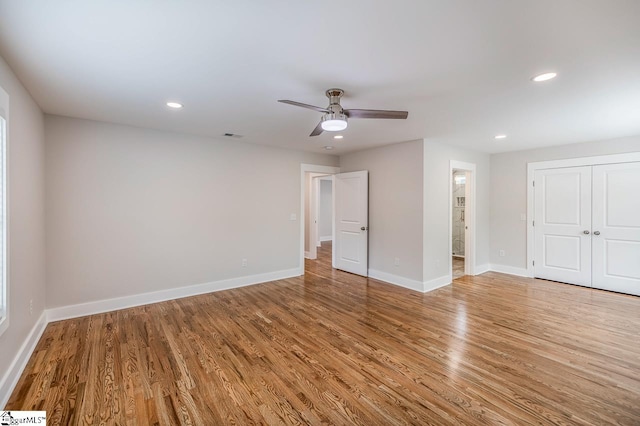 empty room with hardwood / wood-style floors and ceiling fan