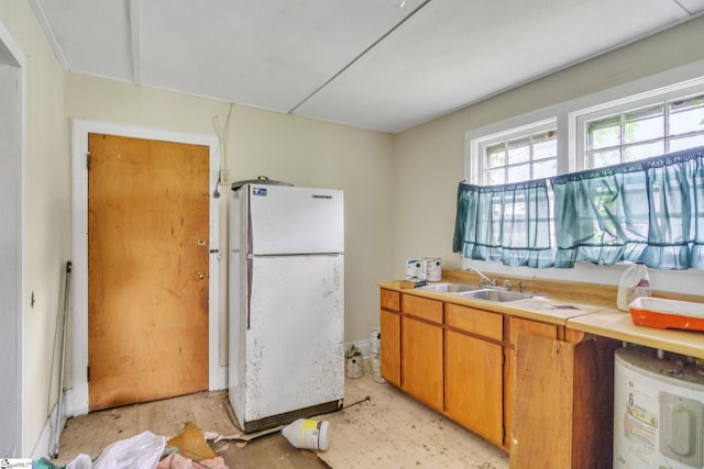 kitchen with white fridge, sink, and electric water heater