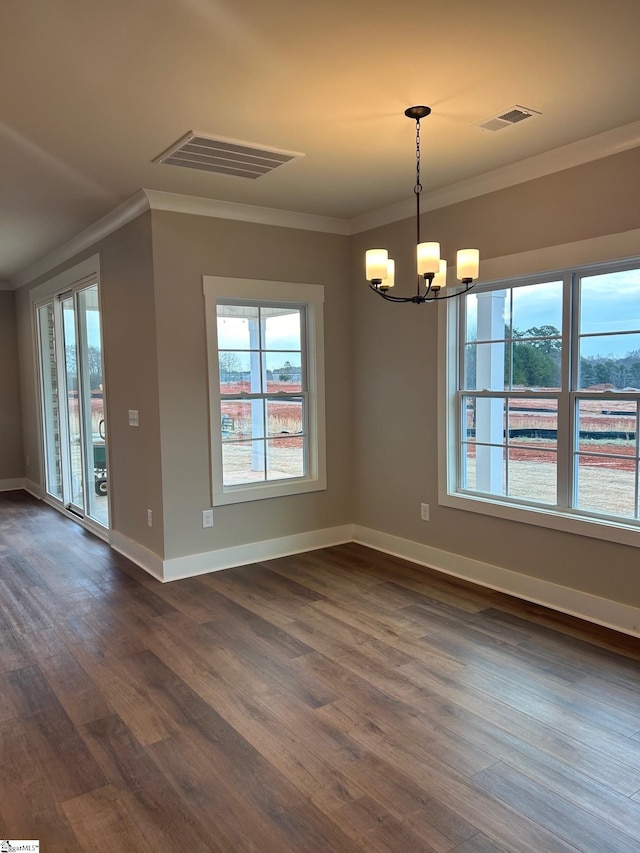 unfurnished dining area with an inviting chandelier, crown molding, and dark hardwood / wood-style floors