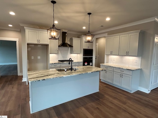 kitchen featuring black oven, wall chimney range hood, white cabinets, and an island with sink