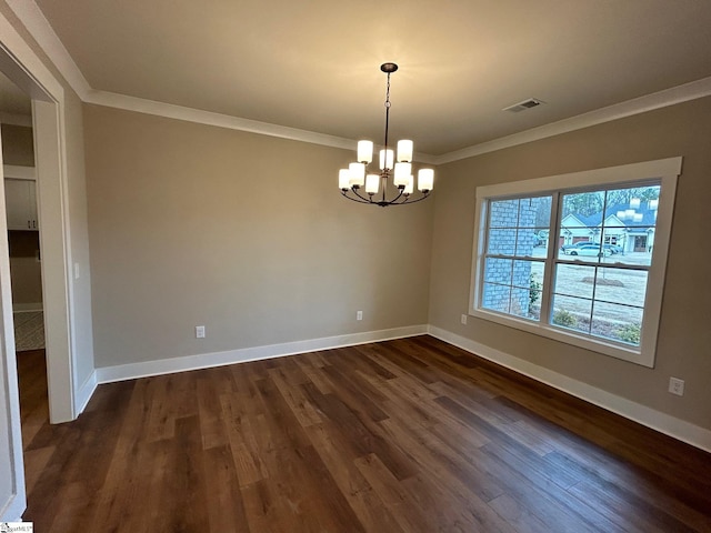 empty room with dark hardwood / wood-style flooring, ornamental molding, and a notable chandelier