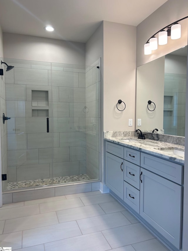 bathroom featuring a shower with door, vanity, and tile patterned flooring