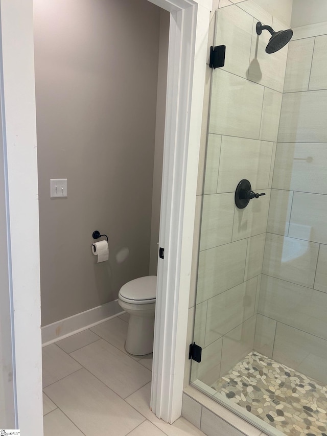 bathroom with tile patterned floors, toilet, and an enclosed shower