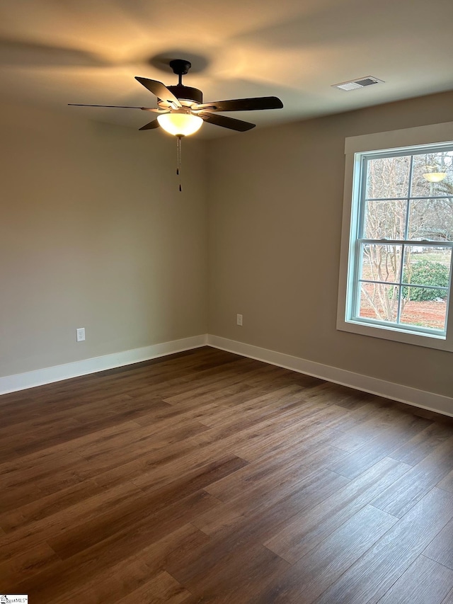 spare room featuring dark wood-type flooring and ceiling fan