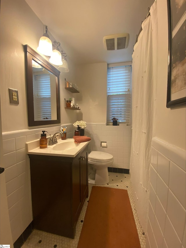 bathroom featuring tile walls, toilet, tasteful backsplash, tile flooring, and vanity