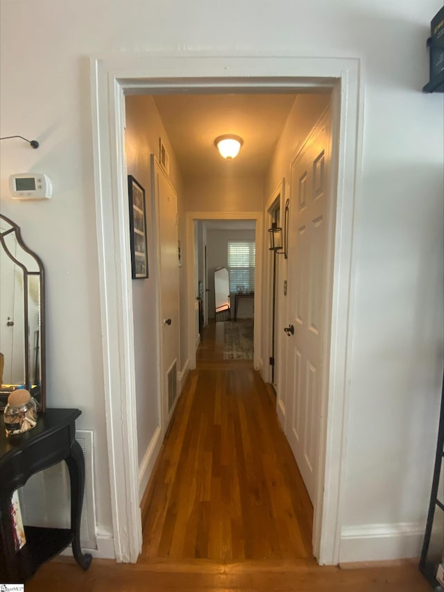 corridor with hardwood / wood-style flooring