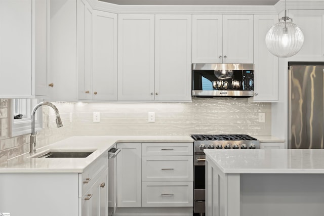 kitchen with stainless steel appliances, decorative light fixtures, sink, and white cabinets