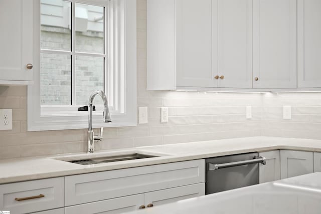 kitchen featuring sink, dishwasher, backsplash, a wealth of natural light, and white cabinets