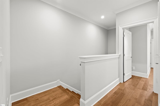 corridor with hardwood / wood-style floors and crown molding