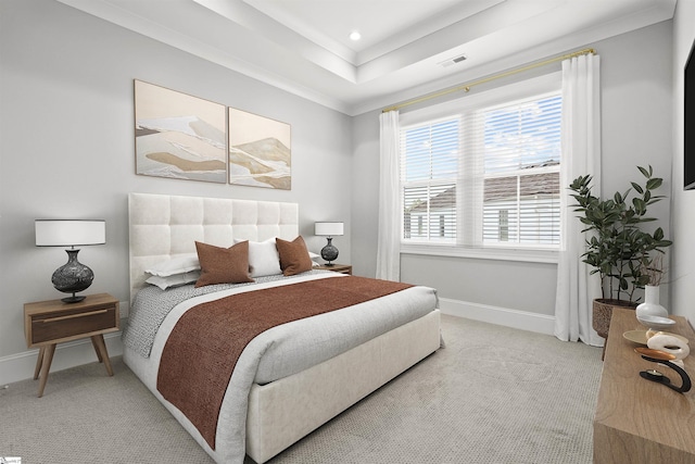 bedroom with light colored carpet and a raised ceiling