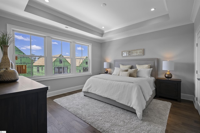 bedroom featuring dark hardwood / wood-style floors and a raised ceiling