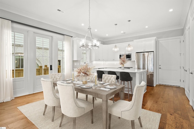 dining space featuring crown molding and light hardwood / wood-style flooring