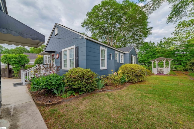 view of side of home featuring a yard and a gazebo