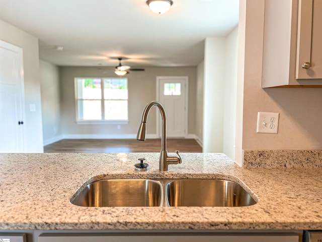 kitchen featuring sink, ceiling fan, light stone countertops, and hardwood / wood-style flooring