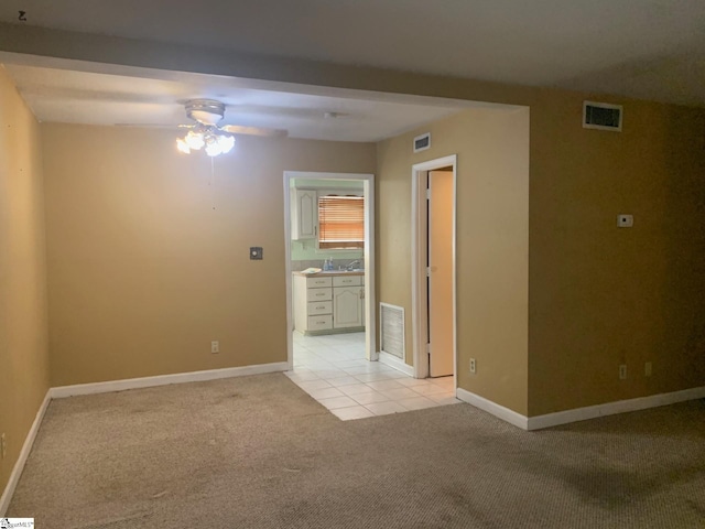 unfurnished room featuring light colored carpet and ceiling fan