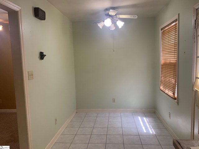 tiled empty room featuring ceiling fan