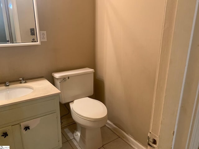 bathroom with toilet, tile flooring, and vanity