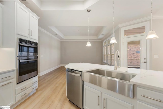 kitchen featuring pendant lighting, white cabinetry, appliances with stainless steel finishes, a raised ceiling, and light hardwood / wood-style floors